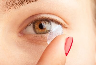 woman putting on contact lenses